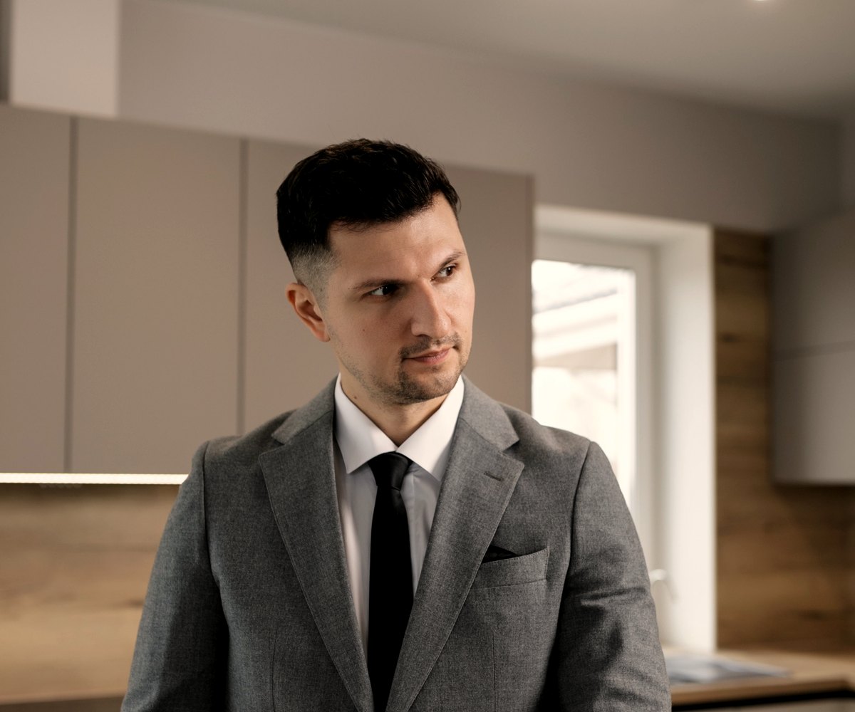 An estate agent in a suit standing in a property interior