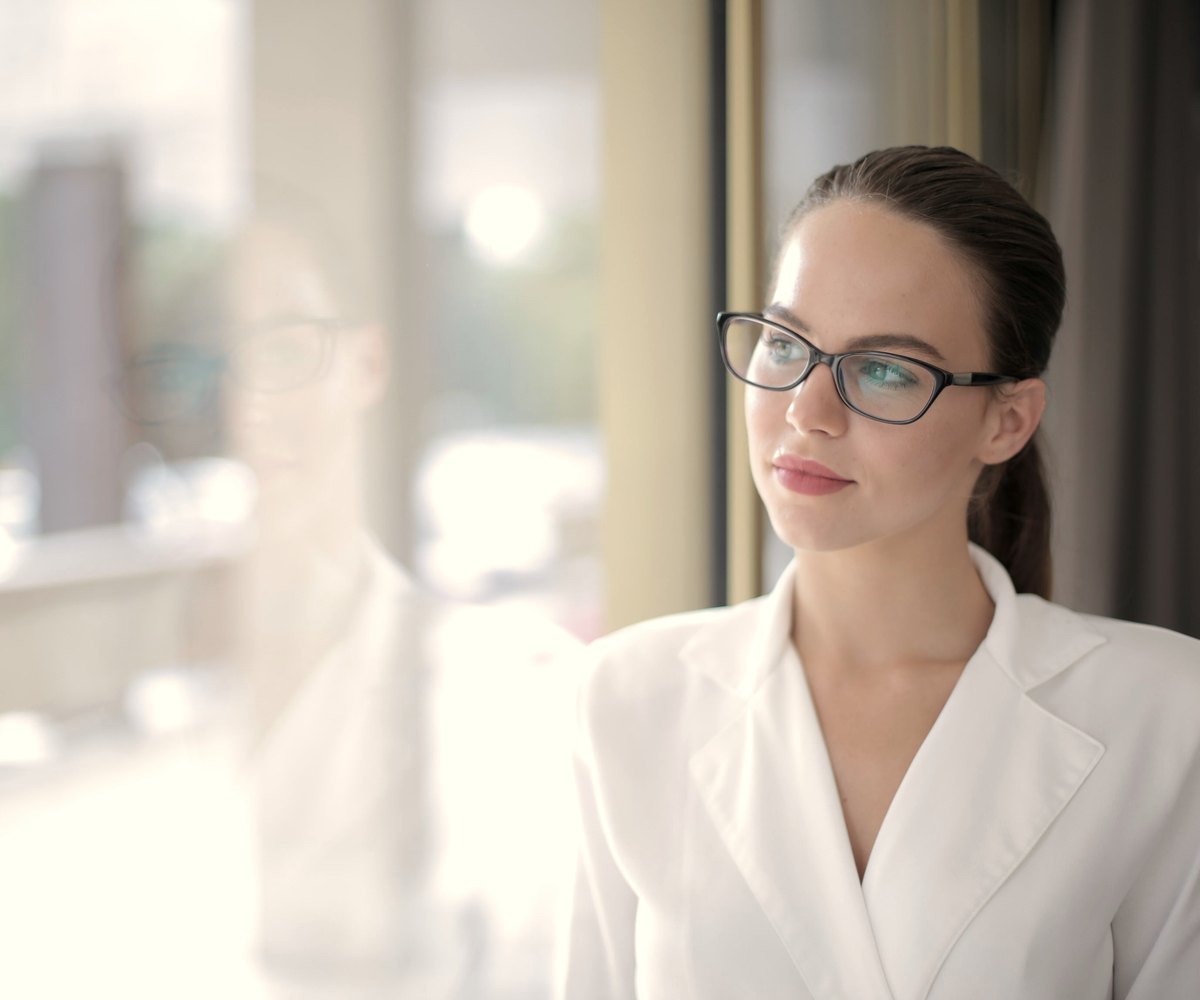 A professional standing by a window in an office